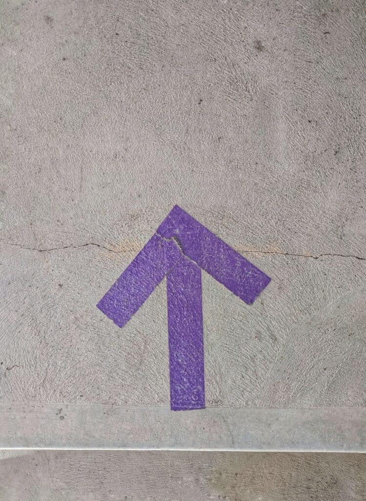 purple and white arrow sign